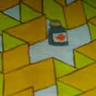 Nesta foto em cores uma superfície arredondada recebe a imagem projetada de um cartum. Percebem-se pessoas em pé e sentadas no chão, em torno da construção. O desenho projetado mostra um homem com roupas de paciente de hospital, apoiado a suporte para soro ou medicação. Ele está em pé, do lado de fora de um labirinto, e tem uma dúvida. Nota-se que dentro do meandro, existe um frasco de medicamento.