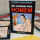 Em close, a foto mostra fôlder com o título: “O gatão e seus amigos. De homem pra homem”. Logo abaixo, há um cartum de mulher e homem nus.