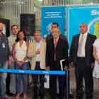 Nesta foto em cores, um grupo de pessoas em pé e lado a lado está de frente para a câmera. Nota-se um grande banner atrás deles e a sigla “SEAP”. Percebem-se também um púlpito e uma bandeira do Brasil. 