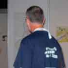 Nesta foto, um senhor passa em frente a um dos cartuns expostos. Nota-se o desenho de dois corações sorridentes dentro de uma camisinha e, logo abaixo, a frase: “Drawing it out”.