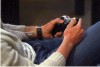 Not�cia: �Videogames podem ser usados para tratar doen�as psicol�gicas�. 
Descri��o da imagem: Fotografia p�e em destaque as m�os de um homem enquanto manipula um controle de v�deo game. O homem est� sentado, com uma perna dobrada sobre a outra, que est� esticada. N�o se v� sua cabe�a, cortada no canto esquerdo da fotografia. Nota-se, por�m, que � jovem, branco, confortavelmente vestido: ele usa um casaco de malha aberto sobre uma camisa branca com estampa e cal�a de jeans escuro. No punho esquerdo, v�-se a pulseira de um rel�gio. Fim da descri��o. 