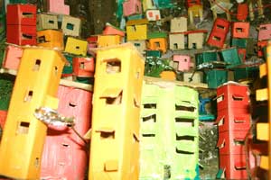 Esta foto em close revela espécie de maquete onde, imediatamente, se reconhece uma favela ou comunidade. Há casas e prédios coloridos, construídos desordenadamente, acompanhando o contorno do morro que ocupam. Esta foto em close revela espécie de maquete onde, imediatamente, se reconhece uma favela ou comunidade. Há casas e prédios coloridos, construídos desordenadamente, acompanhando o contorno do morro que ocupam.